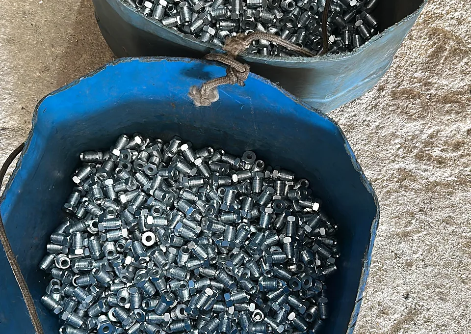 Peças pequenas com acabamento zincado branco em tambor